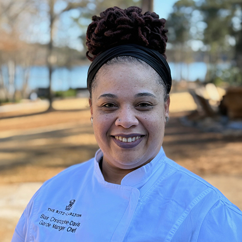 A portrait of Garde Manger Chef Blair Christophe Davis with Lake Oconee in the background.