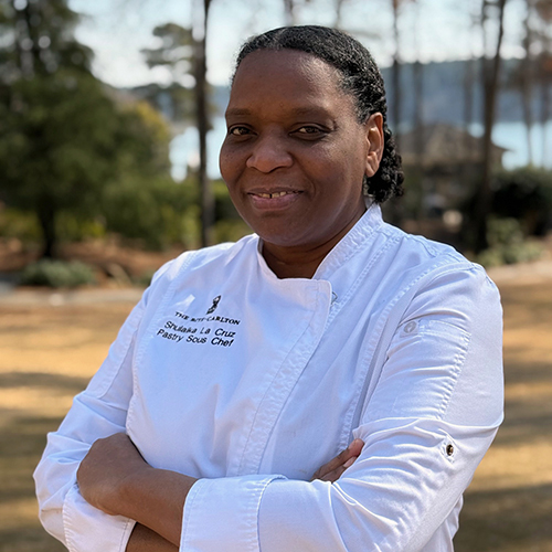 A portrait of Pastry Sous Chef Shulaika “Shuli” La Cruz with Lake Oconee in the background.